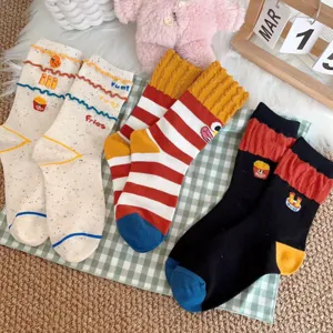 Detailed close-up of cute cartoon fries embroidered mid-calf socks in three colorful styles.