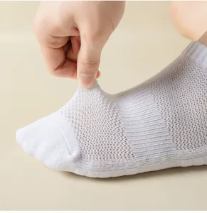 Close-up detail of breathable white athletic mesh short socks showing stretch and fabric texture.