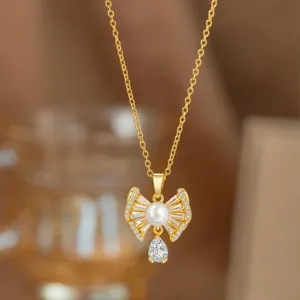 Detailansicht einer goldenen Schleifenkette mit Perle und Zirkonia-Anhänger