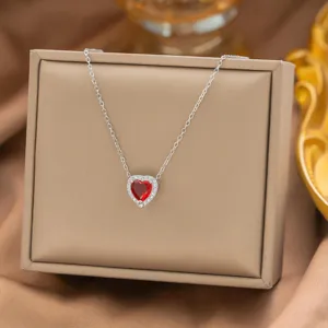 Nahaufnahme einer roten Herz-Zirkon-Halskette mit Pavé-Fassung auf beige Schmuckschatulle