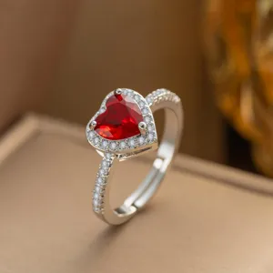 Nahaufnahme eines silberfarbenen Rings mit einem funkelnden roten herzförmigen Edelstein