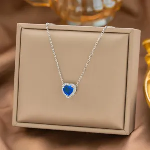Detailaufnahme einer Silberkette mit einem glänzenden herzförmigen blauen Saphiranhänger.