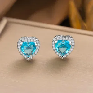 Nahaufnahme der eleganten Herz-Ohrstecker aus Aquamarin mit funkelndem Halo.