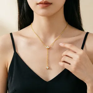 Detailansicht einer eleganten goldenen Y-Halskette mit Quasten an einem Model