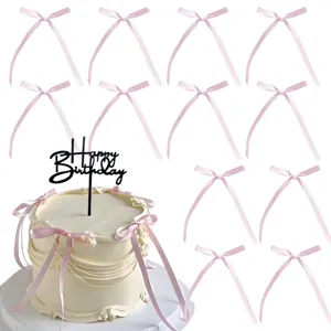 Dettaglio di fiocchi rosa e topper per torta Happy Birthday per decorazione dolciaria.
