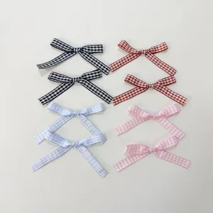 Dettaglio fiocco a quadretti in nastro, piccoli fiocchetti multicolore per fai da te e scatole.