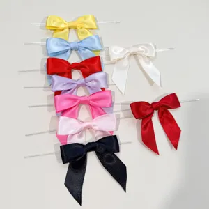 Fiocchi in raso colorati con legature metalliche per confezioni regalo e decorazioni di feste.