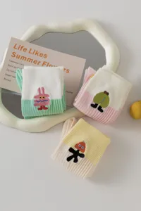 Nahaufnahme von niedlichen bunten bestickten Socken mit lustigen Cartoon-Motiven im Detail.