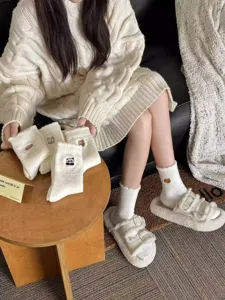 Close-up detail of cute embroidered plush winter socks with cozy fleece lining and soft fabric.