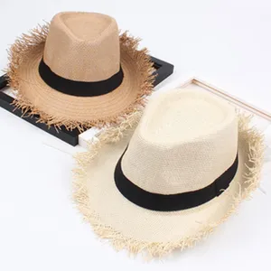 Close-up detail of stylish straw fedora hats with black bands and frayed brims.
