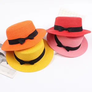 Colorful straw hat with black bow, vintage flat top design, perfect for summer beach sun.