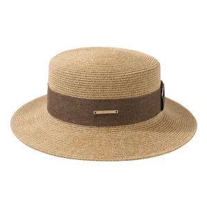 Chapeau de paille plat élégant pour femme avec ruban marron et boucle en métal pour les vacances.