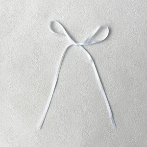 Detail view of minimalist white ribbon bow decoration, elegant for baking and festive desserts.
