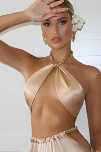 Gold satin halter crop top detail featuring stylish metal chain strap and waist accent.