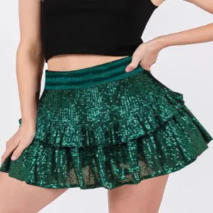 Close up view of the green sequin tiered mini skirt detail, sparkly party wear apparel piece.
