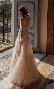 Detailed view of the elegant sheer tulle evening dress in a vintage architectural setting.