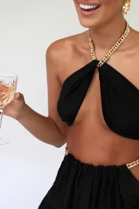 Women sexy black two piece set with gold chain halter top and skirt, fashion party outfit detail.