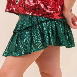 Green sequin tiered ruffle mini skirt detail, sparkly party clubwear apparel close up view.