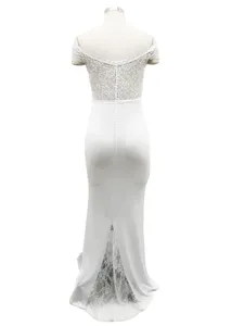 Detailed view of the elegant white lace off-shoulder evening dress back design and buttons.