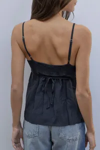 Back detail view of a dark camisole featuring adjustable thin straps and smocked bodice.