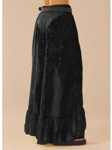 Detailansicht des schwarzen asymmetrischen Spitzemaxirocks mit feiner Textur und Design.
