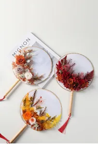 Vista dettagliata di ventaglio rotondo cinese artigianale con fiori secchi e design floreale.