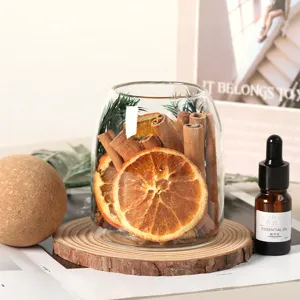 Aromatherapie-Glasflasche mit getrockneten Orangenscheiben und Zimtstangen für Dekor.