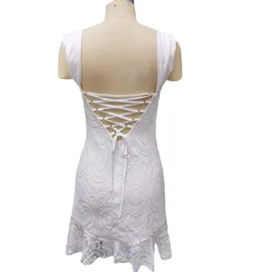 Back detail shot of white lace mini dress featuring a sexy open back and lace-up straps.