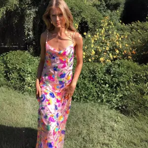 Elegant pink sequin floral camisole long dress featuring gold chain straps and chic side slit.