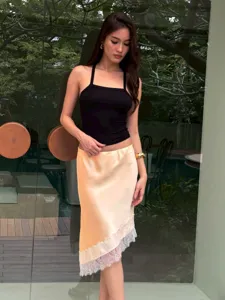 Detailed view of the stylish asymmetric satin midi skirt with elegant lace hem and slim fit.