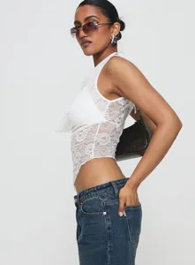Detail shot of women white lace halter camisole top paired with classic blue denim jeans.