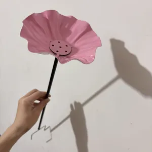 Detailansicht eines rosa Metallblumen-Vogelfutters mit schwarzem Stab und Zackenfuß