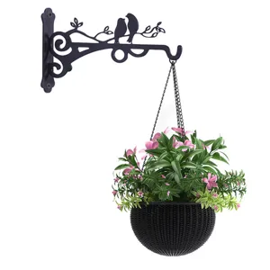 Dekorative Wandhalterung im Vogel-Design mit einem hängenden Korb voller rosa Blumen