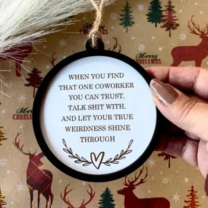 Detailaufnahme einer lustigen Weihnachtskugel für Kollegen mit humorvollem Spruch in Festtagsdekor