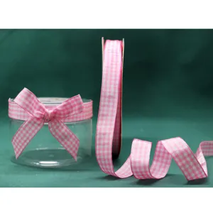 Close-up detail view of pink and white gingham ribbon roll and elegant bow decoration.