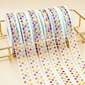 Close-up of translucent organza ribbon with colorful polka dots, neatly displayed on a gold rack.