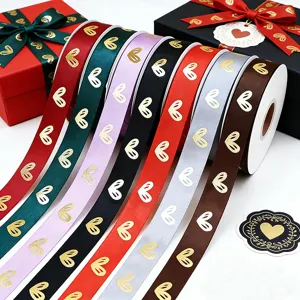 Detalle de cinta estampada con corazones dorados, ideal para envolver regalos y ramos de flores.