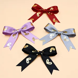 Lazos de cinta de satén con estampado de corazones dorados para regalos, ramos y decoración.