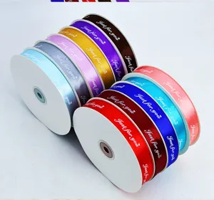 Detailed view of colorful satin ribbon rolls featuring printed english text for gift wrapping.