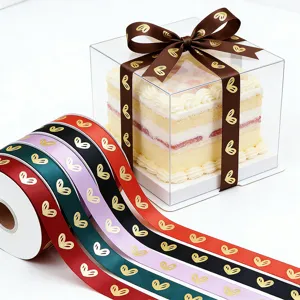 Rollo de cinta de satén multicolor con estampado de corazones dorados para regalos y flores.