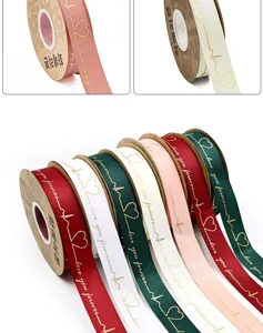 Close-up details of gold-stamped heart ribbon rolls showing premium texture and fine print quality.