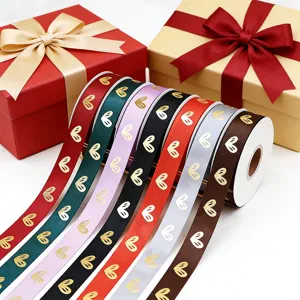 Vista detallada de cintas coloridas con corazones dorados para empaques de regalo y ramos florales.