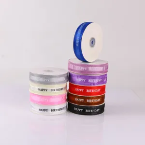Close-up of colorful birthday ribbon spools, 2.5cm satin webbing for gift wrapping.