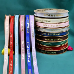 Detailed close-up of colorful grosgrain gold stamping love ribbons for gift box and flower packing.