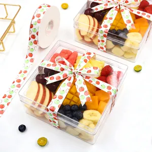 Gedetailleerd overzicht van transparante fruitgeschenkdoosverpakking met decoratief lint.