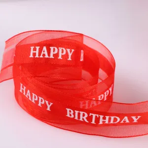 Red organza ribbon close up detail, Happy Birthday printed textile for gift wrapping.