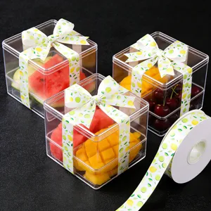 Transparante fruitcadeau dozen met citroenprint linten, ideaal voor verse fruitgeschenken.