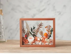 Vue détaillée du cadre de fleurs séchées en bois massif, décoration botanique artisanale.