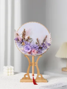 Ventaglio rotondo artigianale in stile cinese con fiori preservati e supporto in legno.