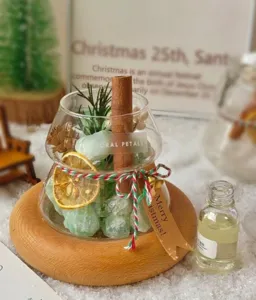 Detalle en primer plano de un difusor de aroma de cristal navideño con tarro y aceite.
